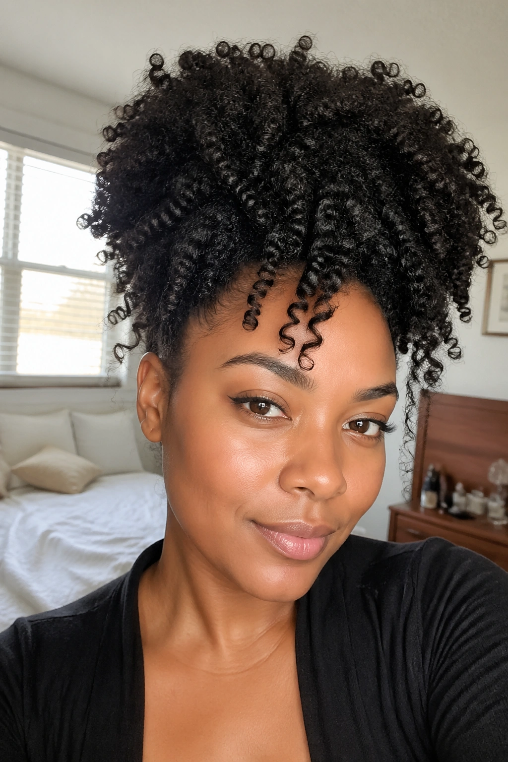 Portrait showing a voluminous 4A/4B curly updo on a real woman