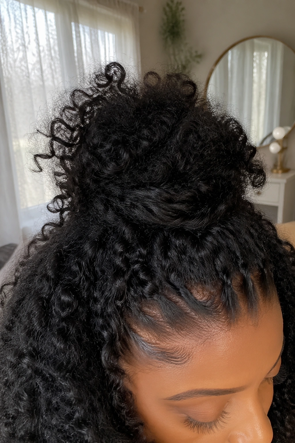 Close-up crown bun on big afro curls showcasing airy texture