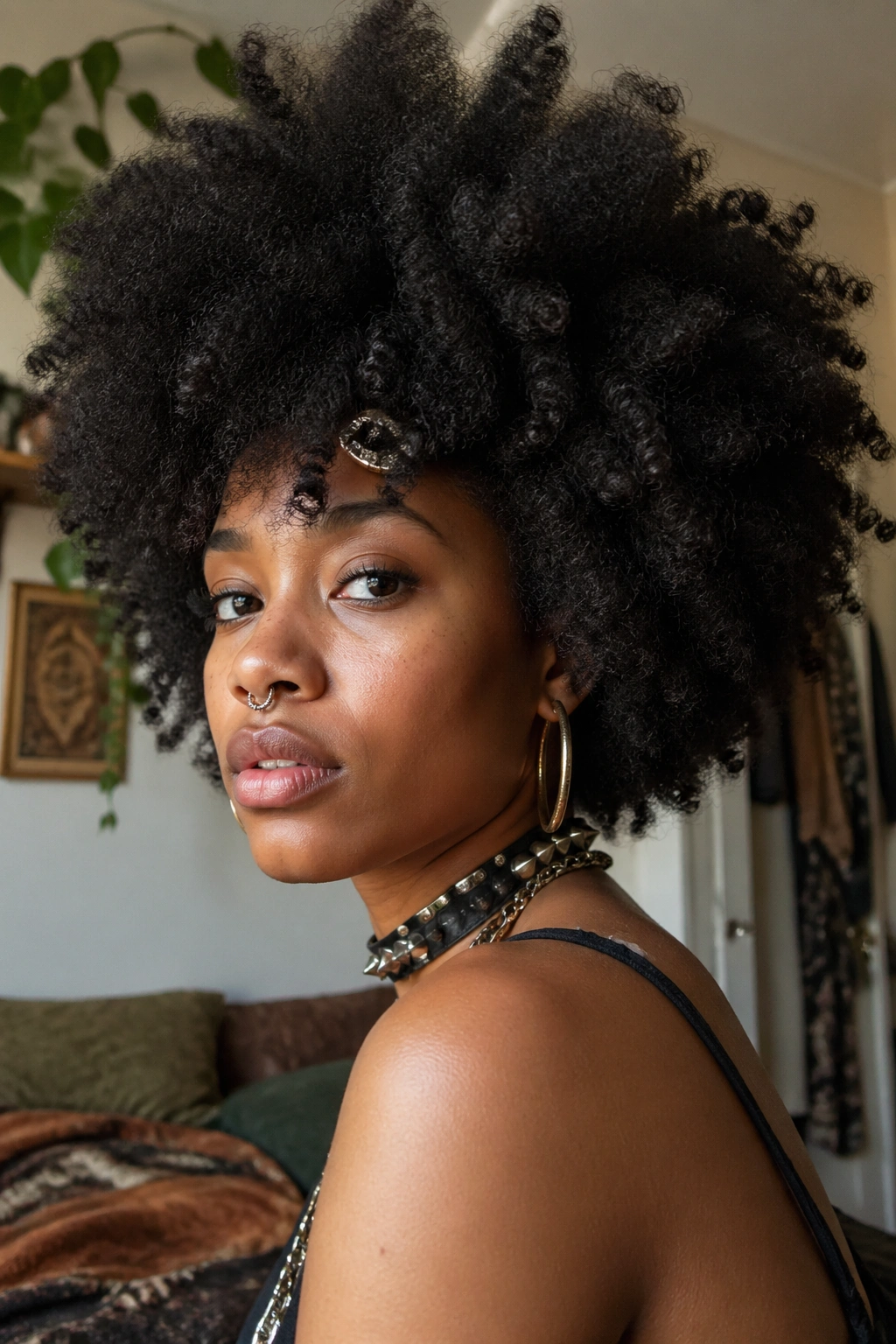 Close-up of voluminous natural afro hair on a real Black woman with soft window light.