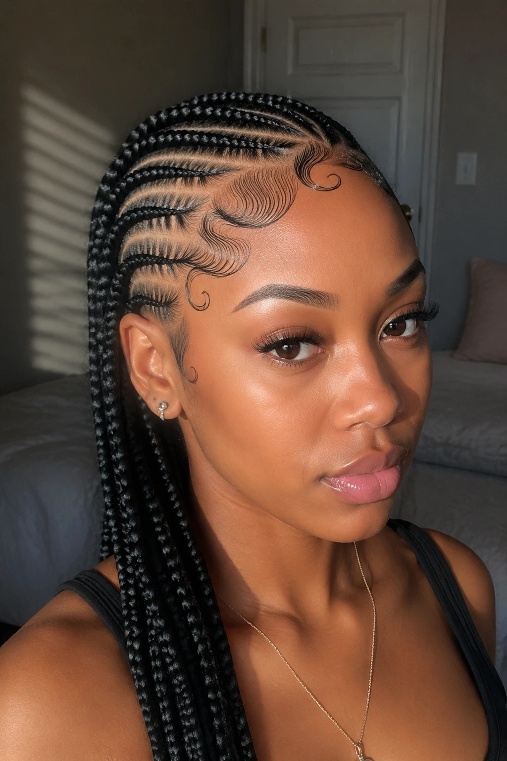 Woman with side cornrows and intricate baby hair edge design along hairline