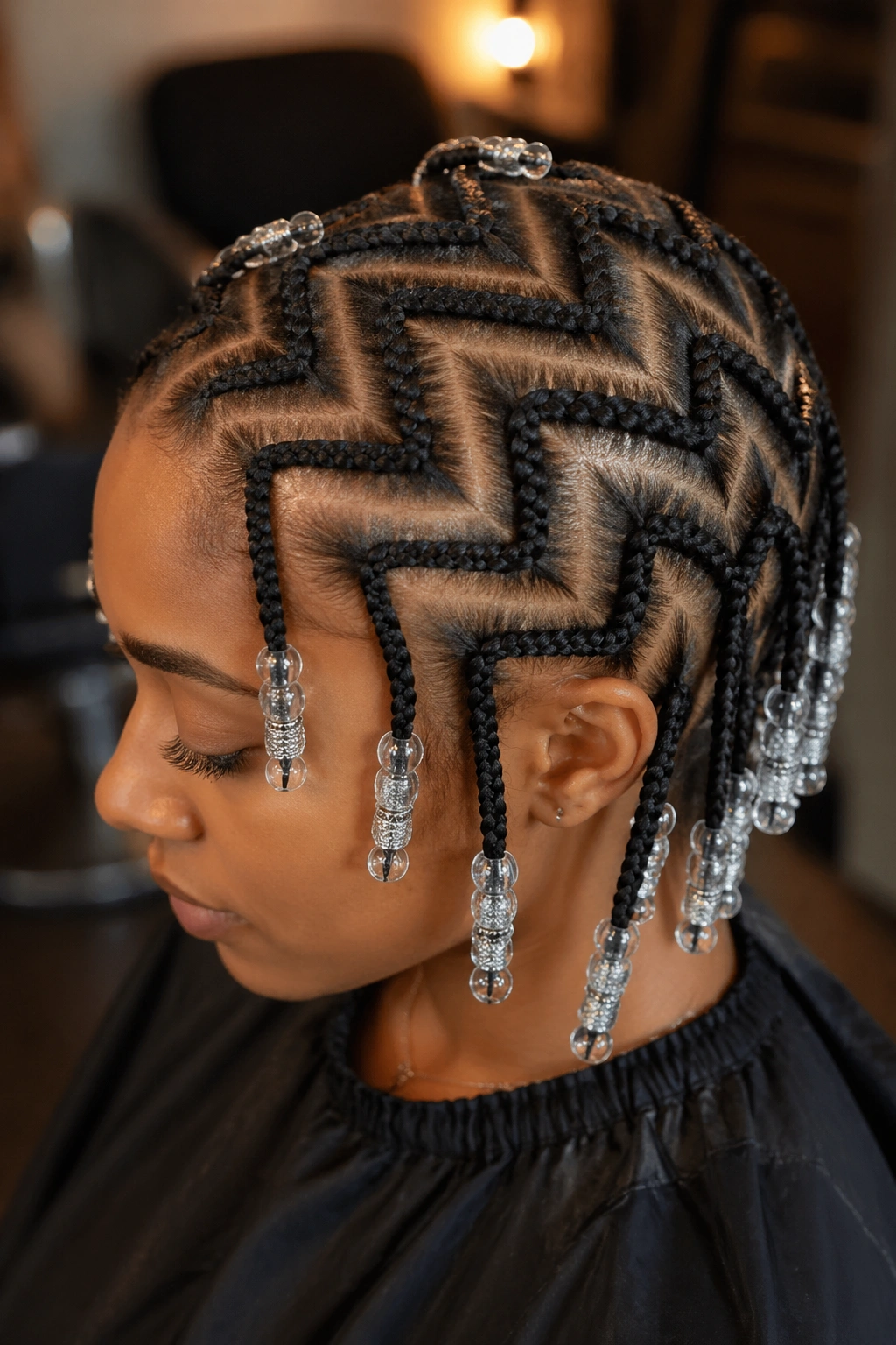 Close-up of zigzag cornrows with beads at tips on a real person's head