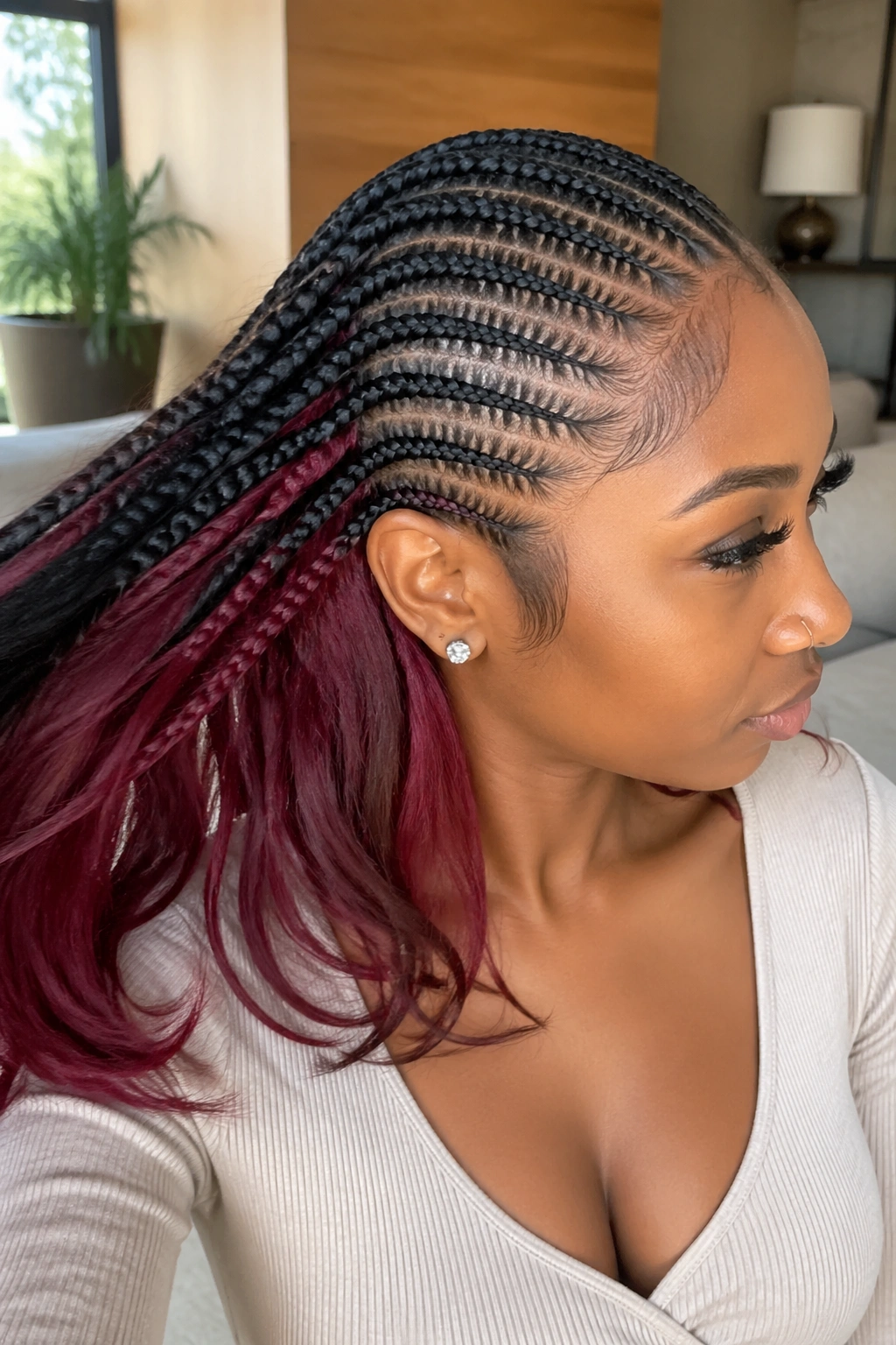 Close-up of a real woman's cornrows with a burgundy underlayer visible