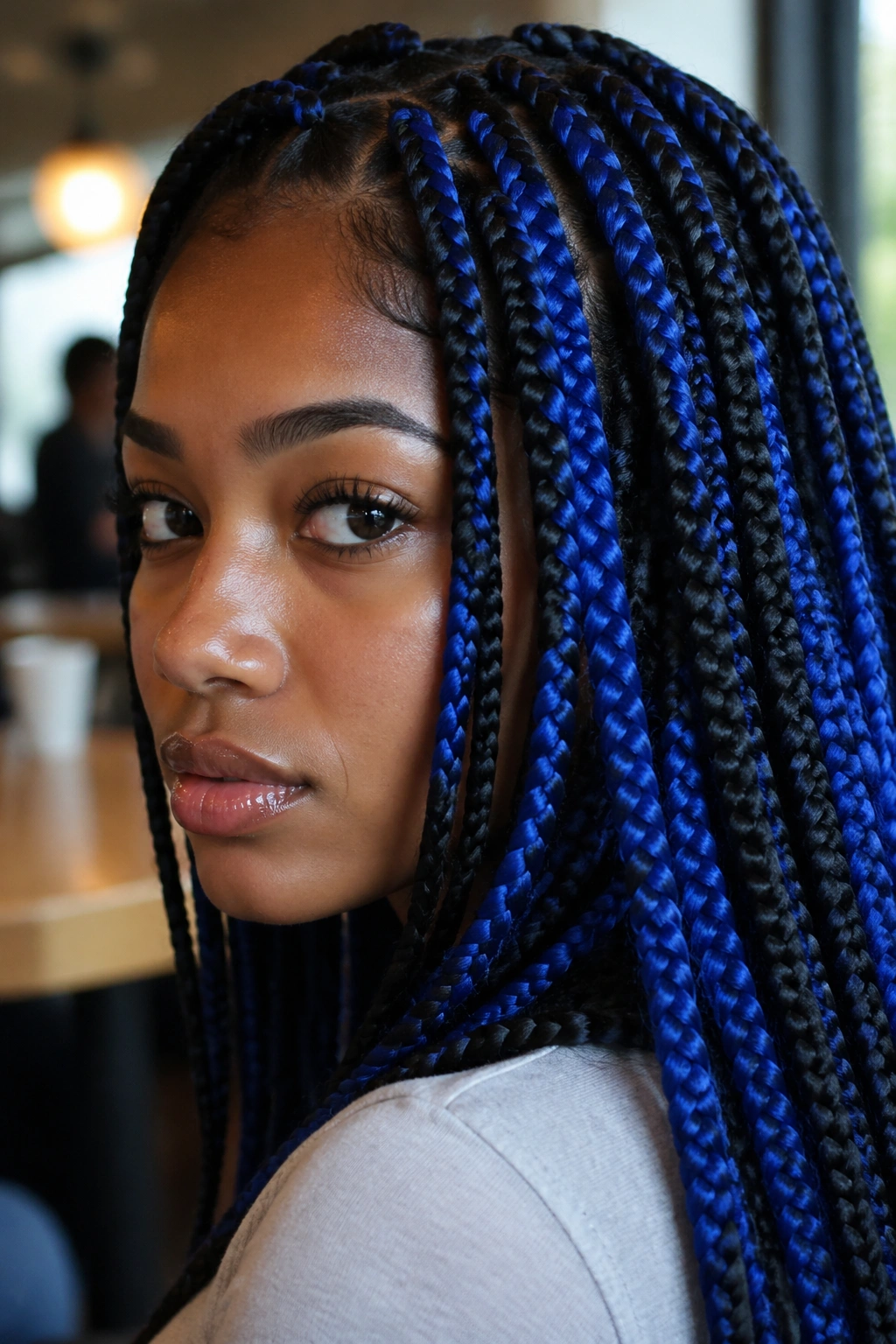 Close-up of real person wearing blue-and-black box braids