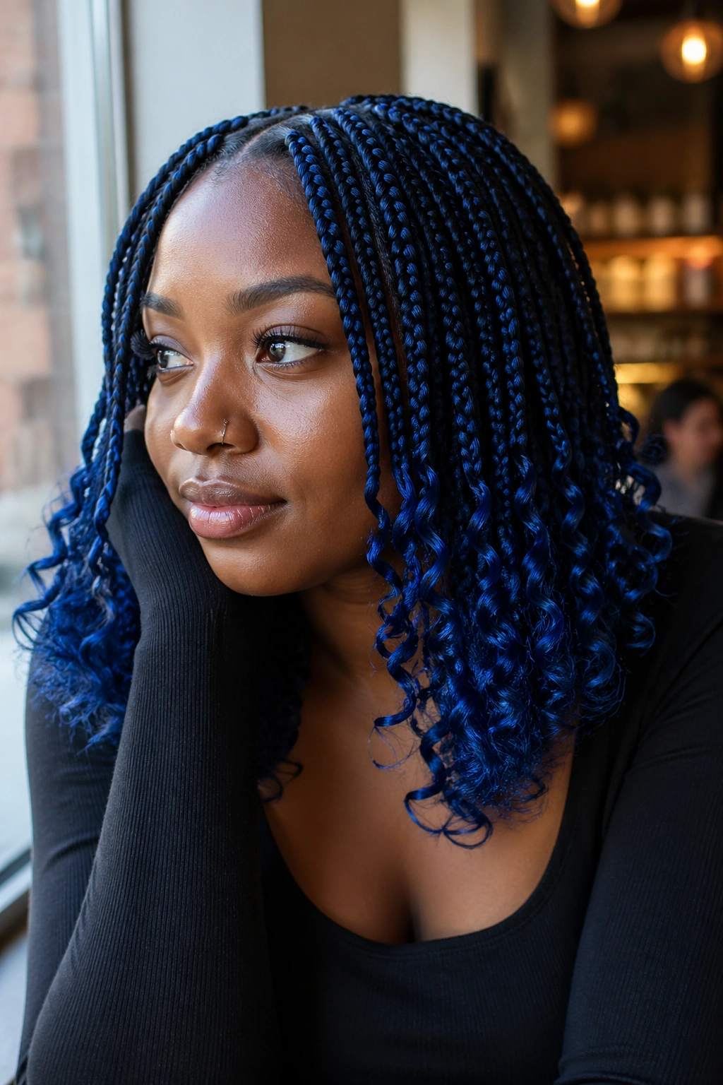 Real person with blue box braids ending in loose curls in natural light.