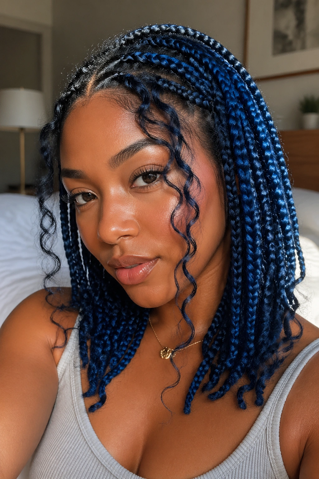 Close-up of a real person with blue goddess box braids framing the face and tendrils near temples