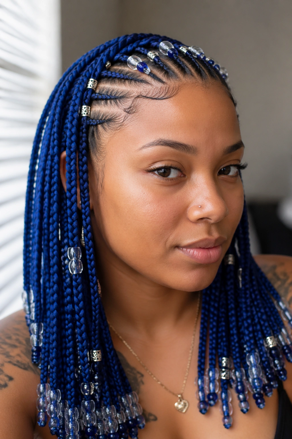 Close-up of blue knotless box braids with a beaded cornrow crown