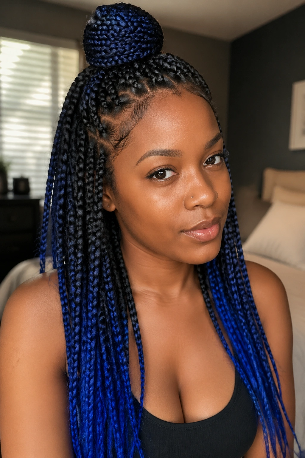 Close-up of real woman showing half-up half-down blue ombré box braids.