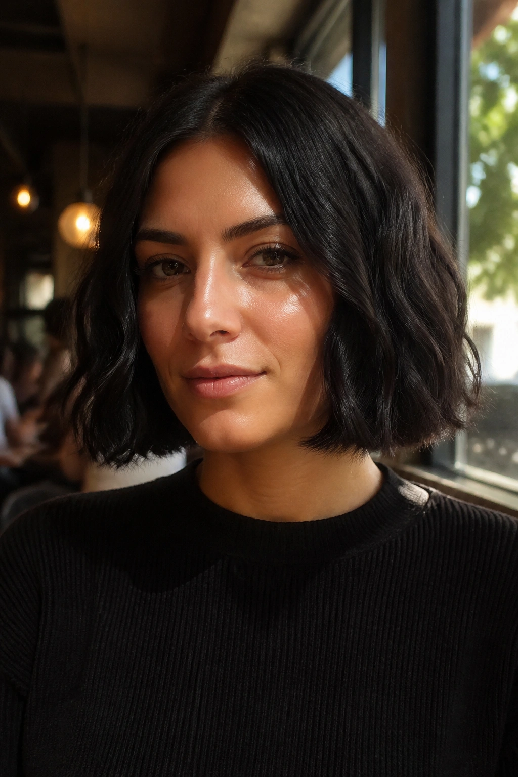 Close-up of a real woman with jaw-length blunt-cut wavy bob in black hair