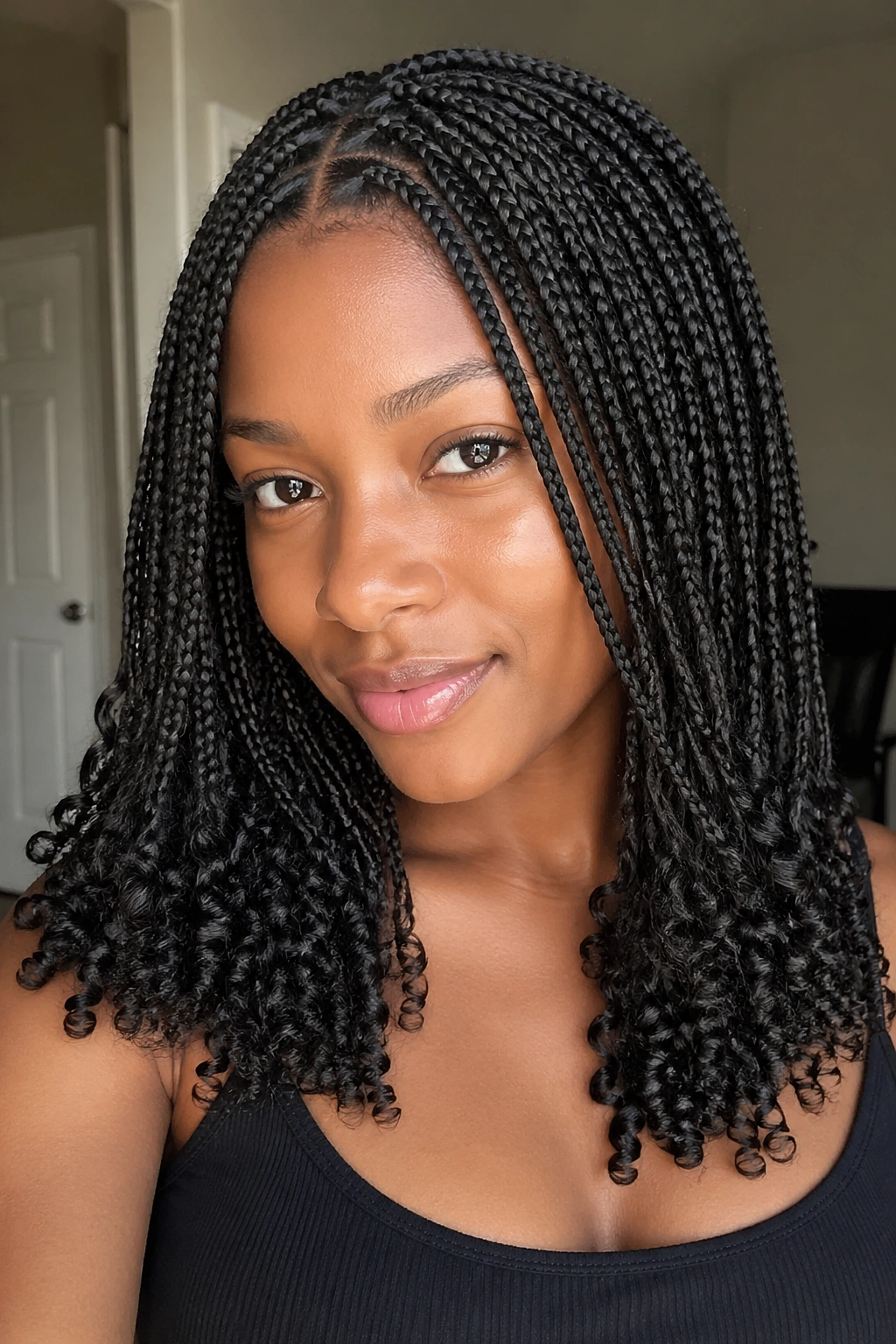 Close-up of a real person with small box braids and tight ringlet ends.