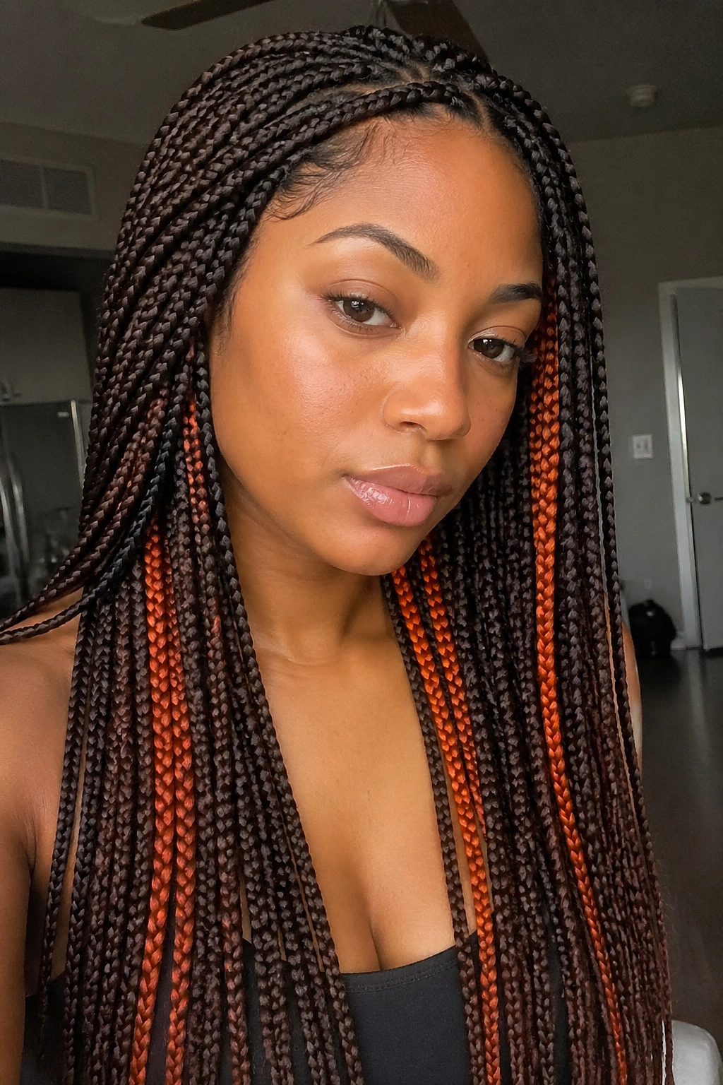 Close-up of brown box braids with orange peekaboo panels beneath