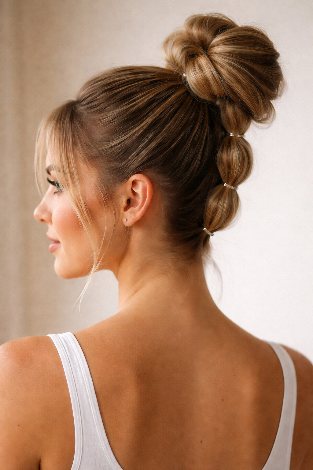 High bun with bubble sections formed by elastics along the ponytail