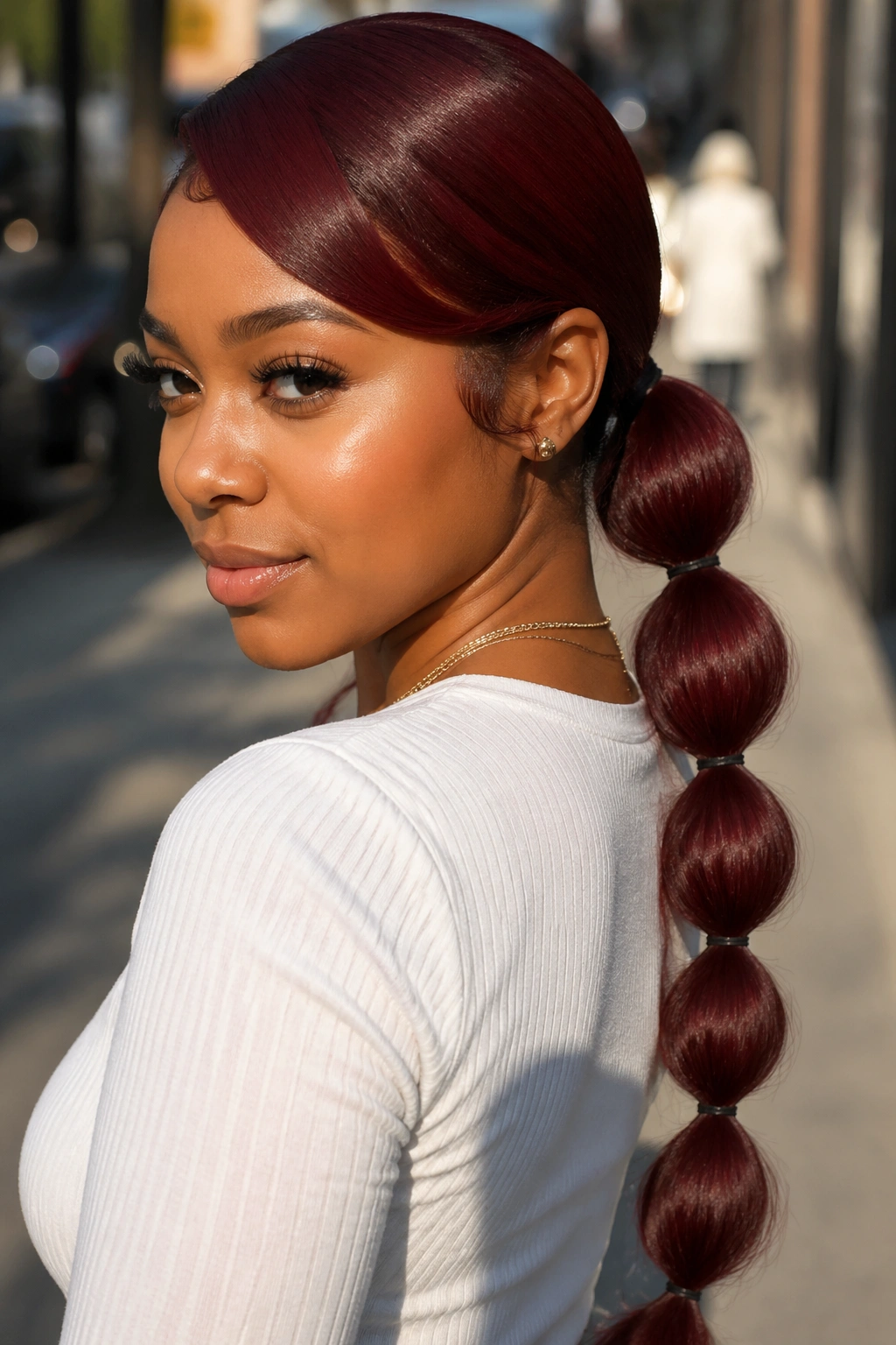 Real woman with bubble burgundy swoop ponytail featuring segmented bubbles