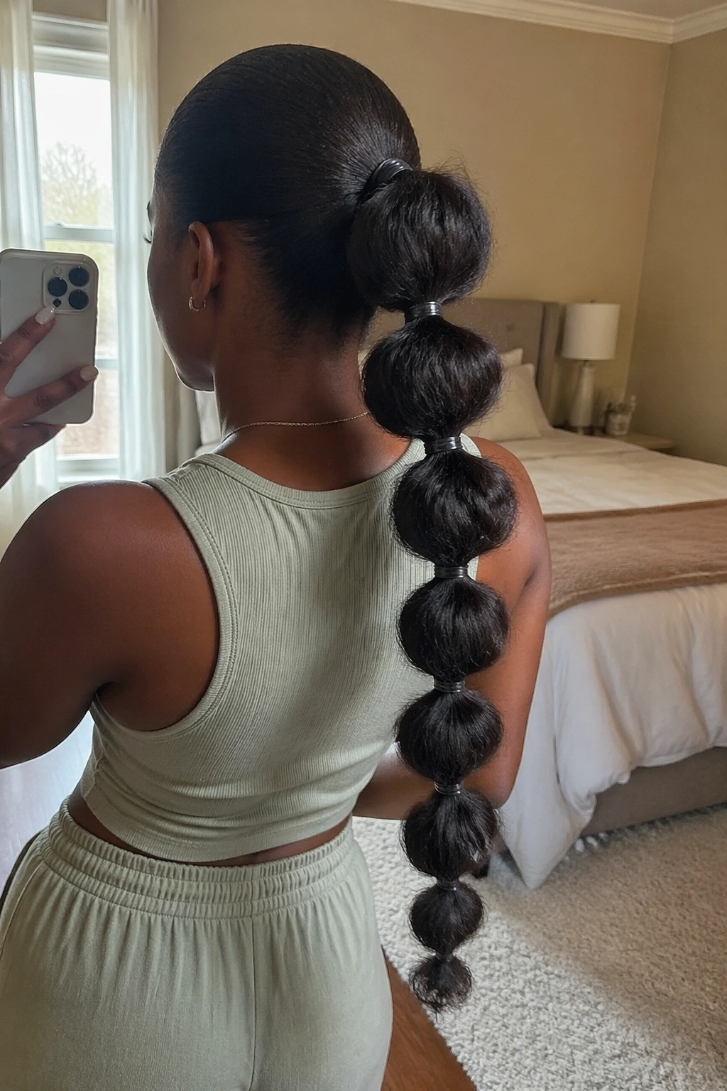 Over-the-shoulder selfie showing bubble ponytail along textured sections.