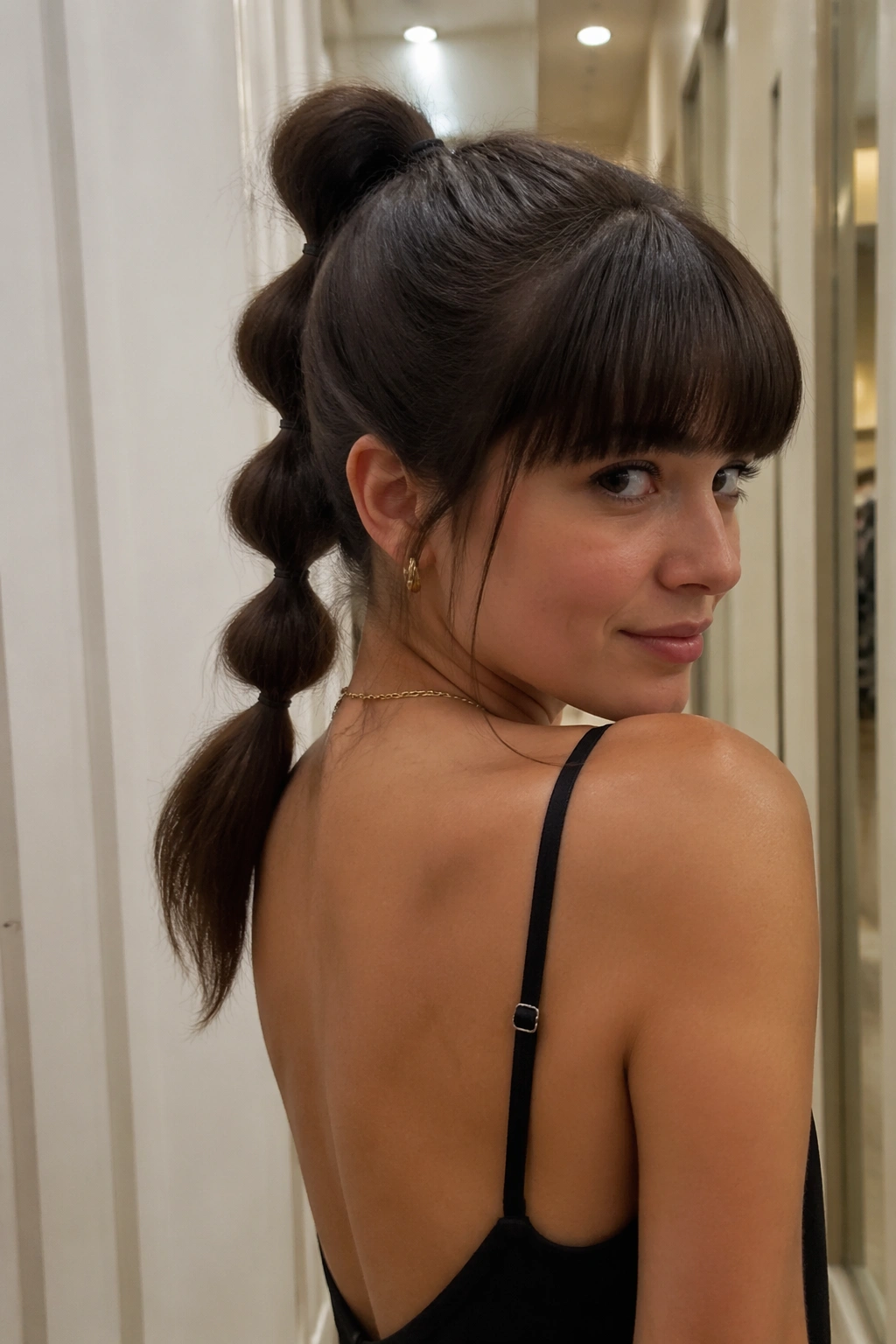 Bubble ponytail with blunt bangs in a candid hallway shot