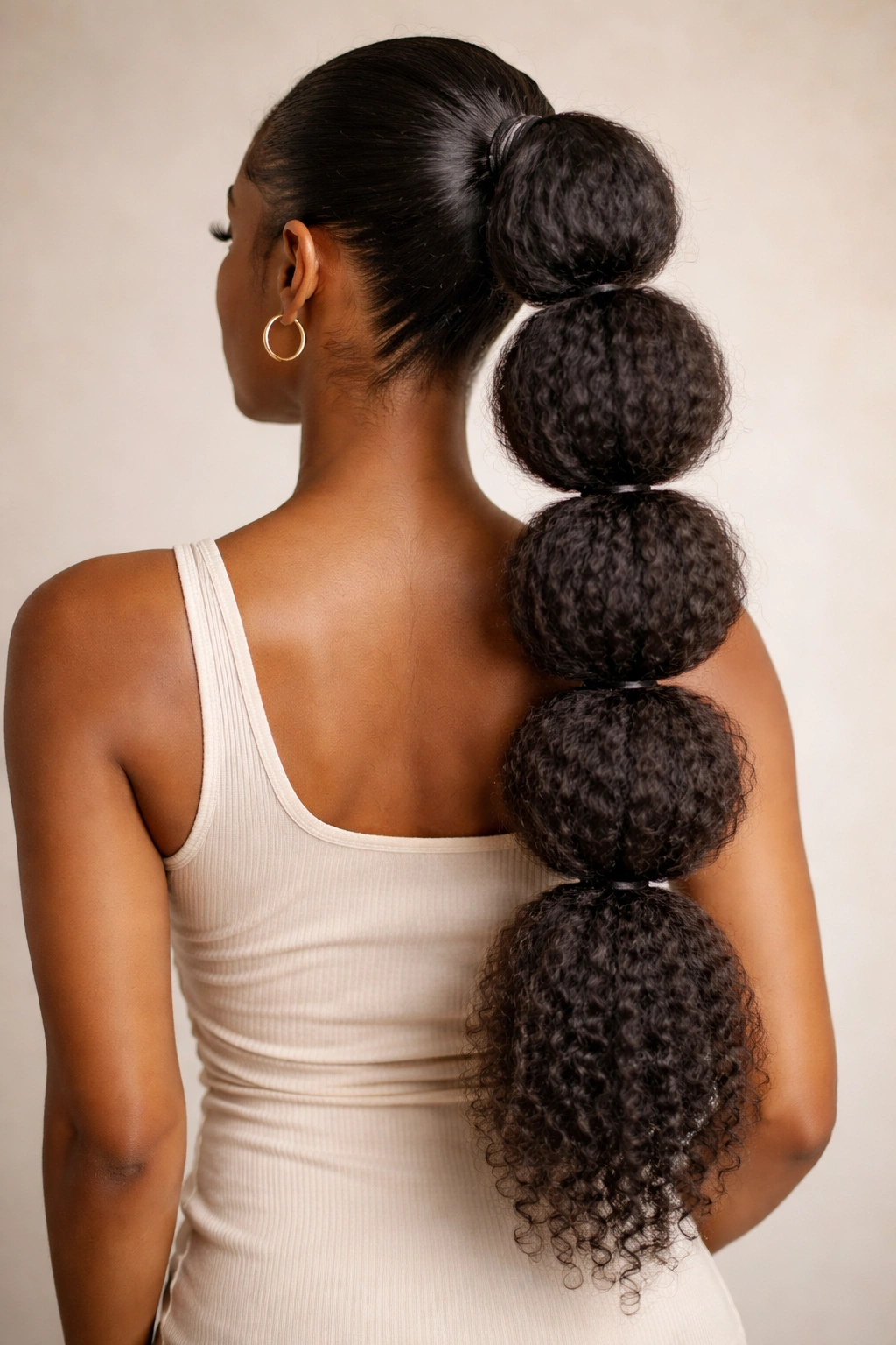 Bubble ponytail with elastic segments along its length in natural texture.