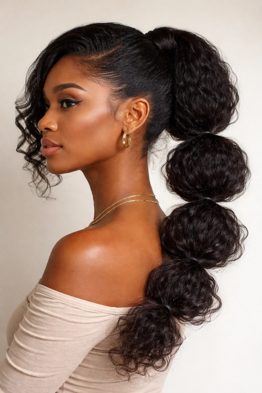 Side profile showing a side-swept bubble ponytail draping over the shoulder