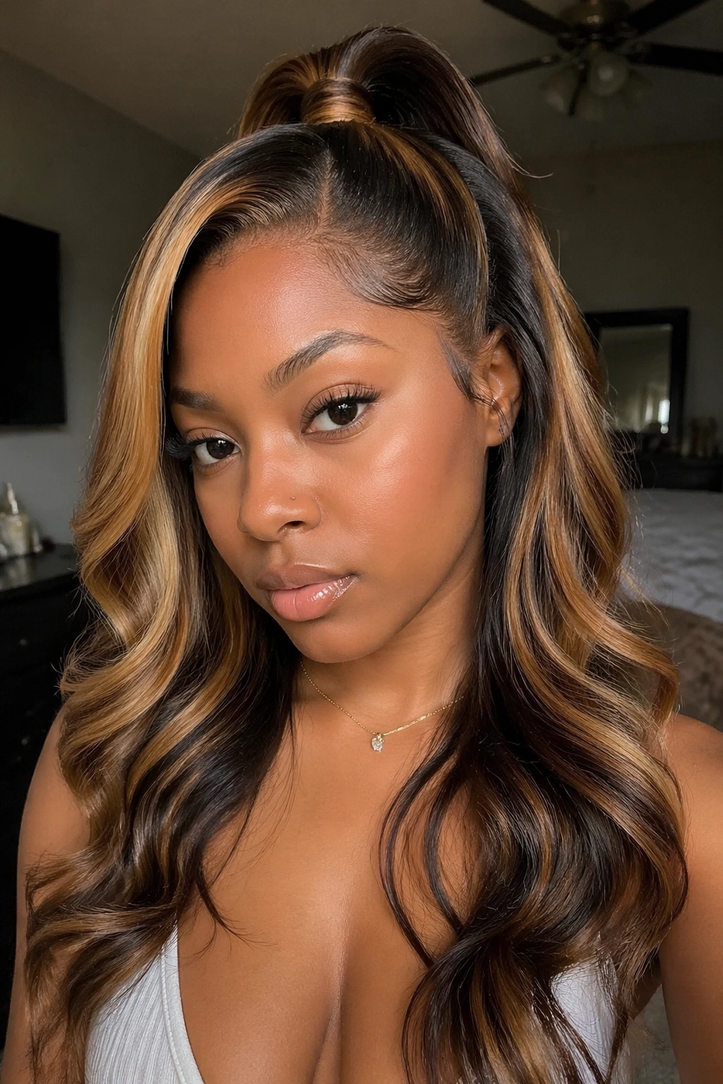 Close-up of a real woman with caramel-highlighted half-up half-down weave framing the face