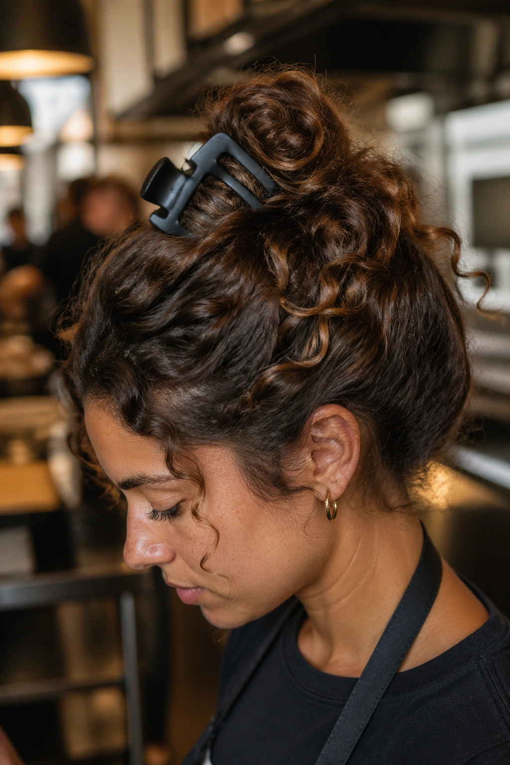 Close-up of a real woman wearing a shell twist secured by a wide claw clip at the crown
