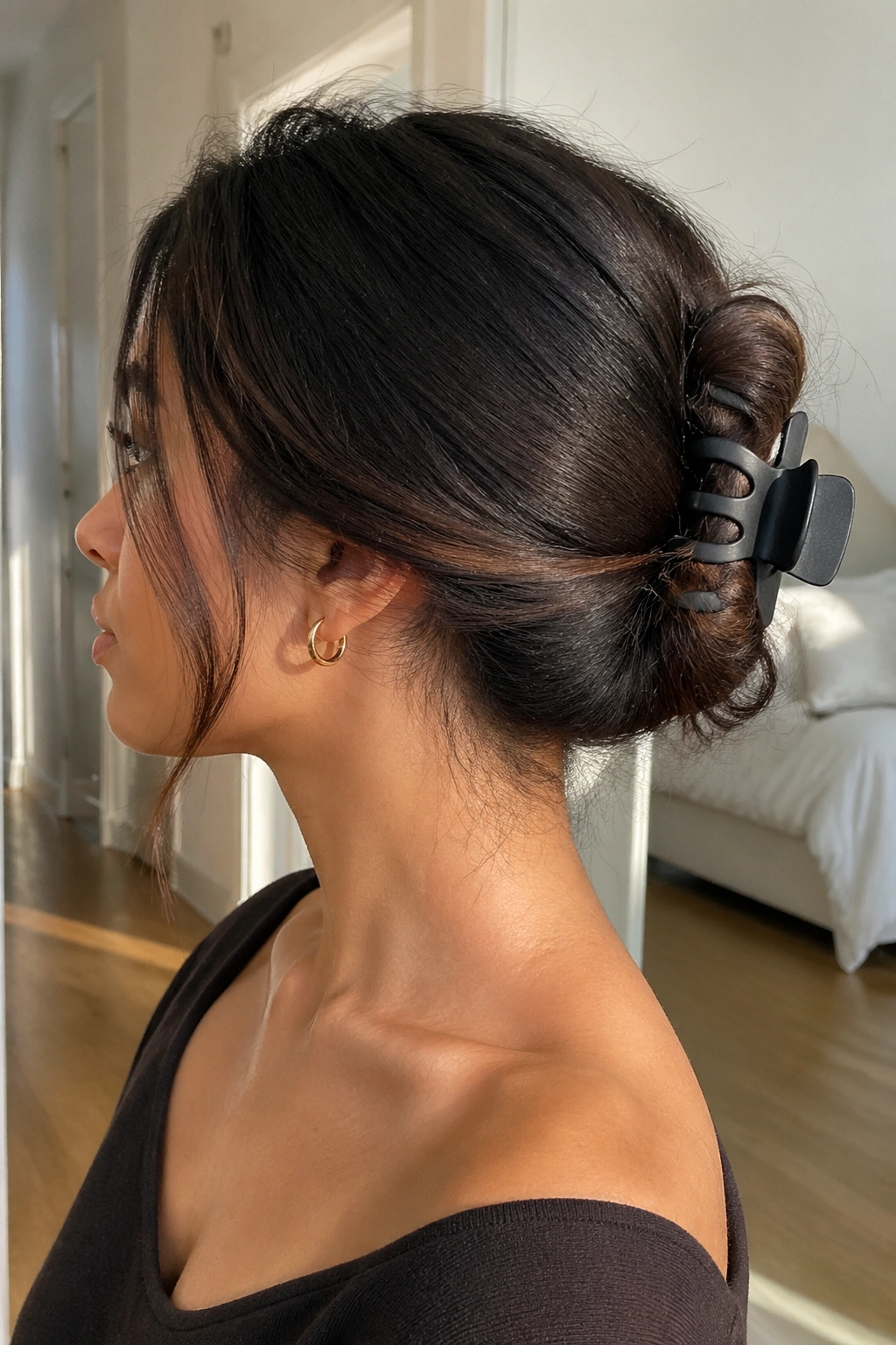 Profile view of a real woman with a twisted hairstyle secured by a matte claw clip