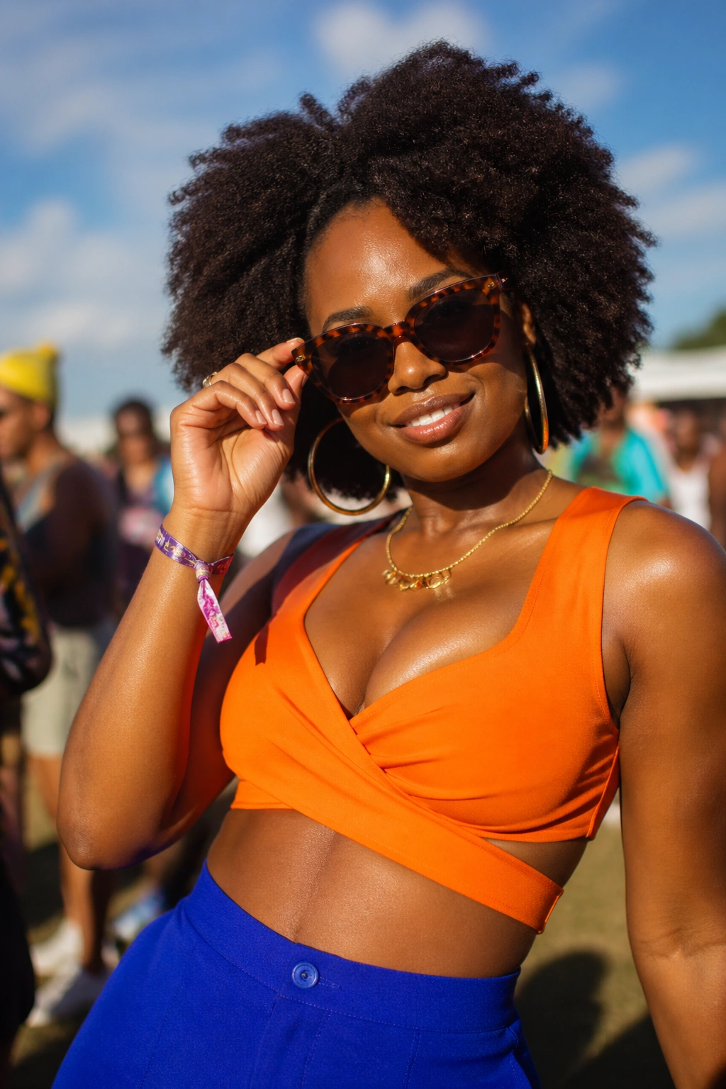 Real person in orange and cobalt color-block outfit at a sunny outdoor festival