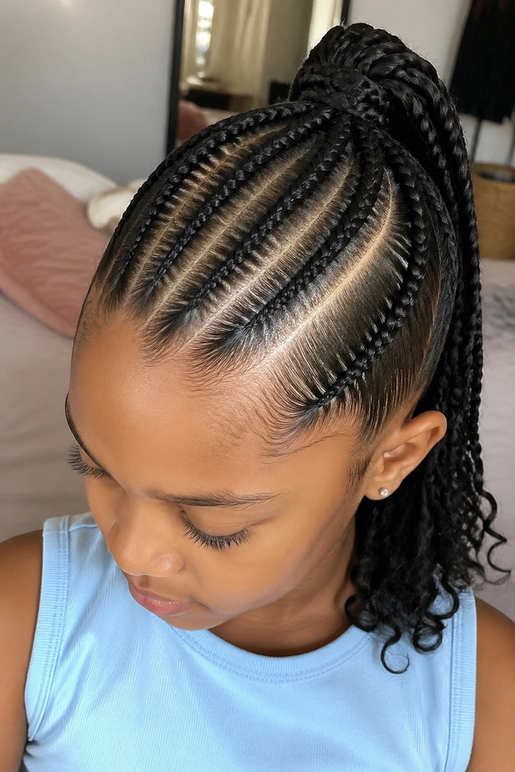 Real child with cornrow ponytail and deep side part in a cozy setting.