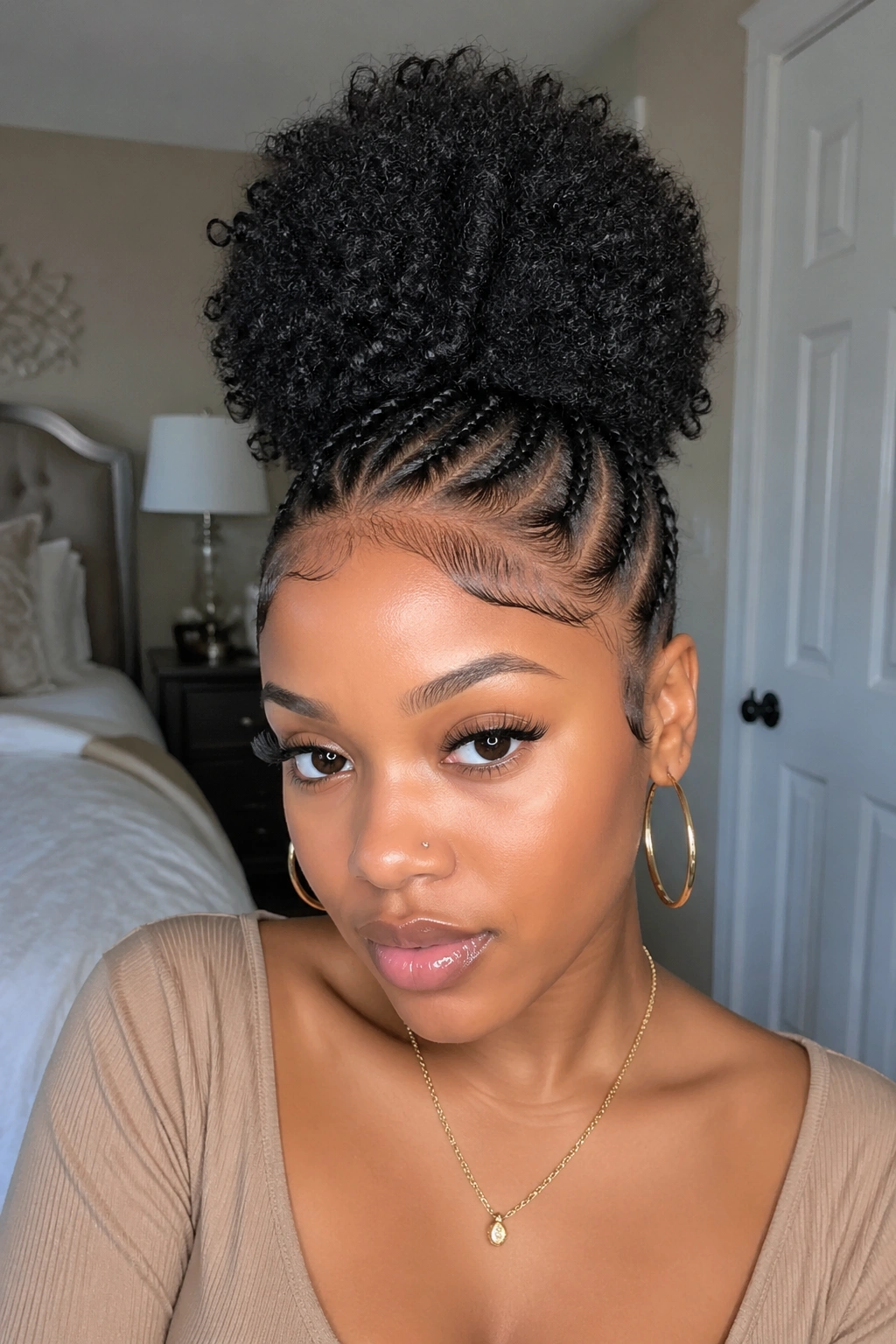 Portrait of a woman with cornrows and a top puff.