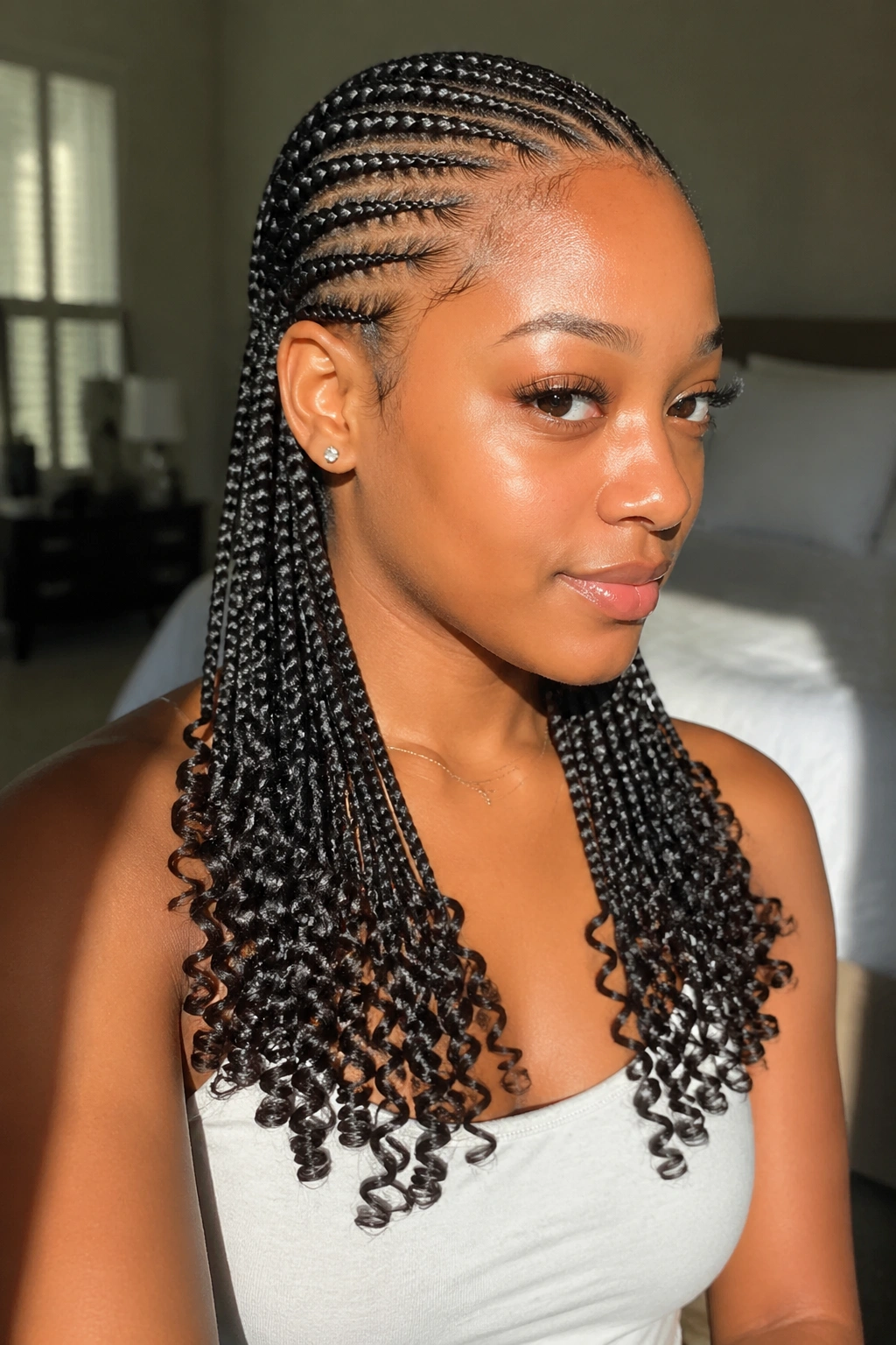Close-up of a real woman with long cornrows ending in tight ringlets.