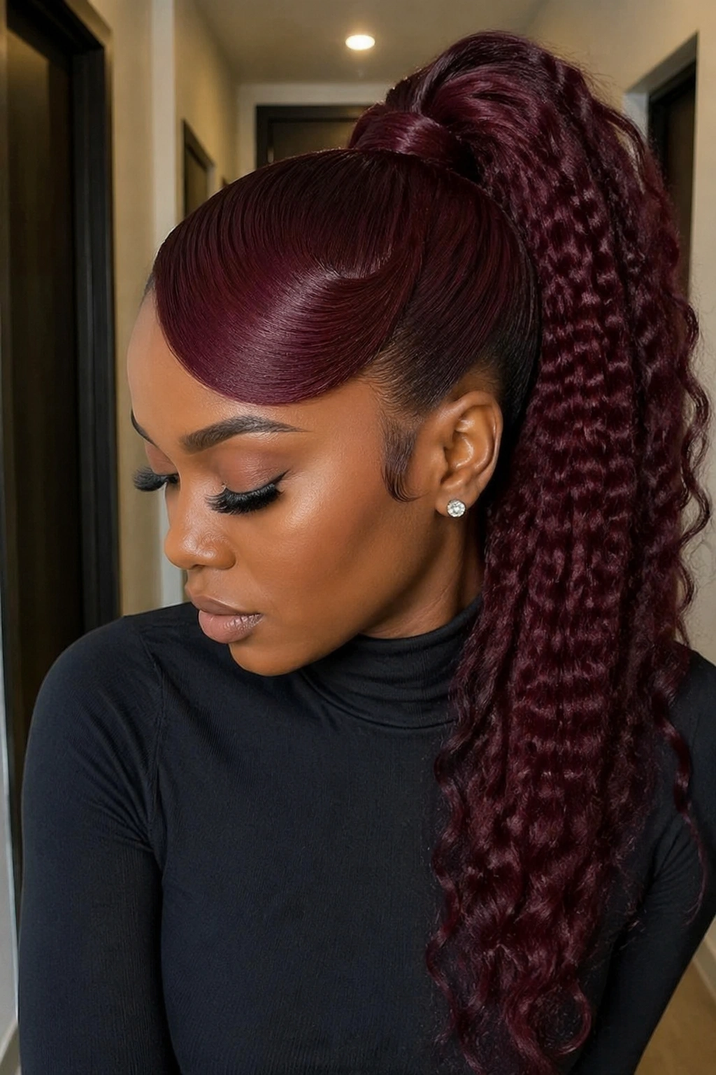 Real woman with crimped burgundy swoop ponytail in a modern apartment hallway