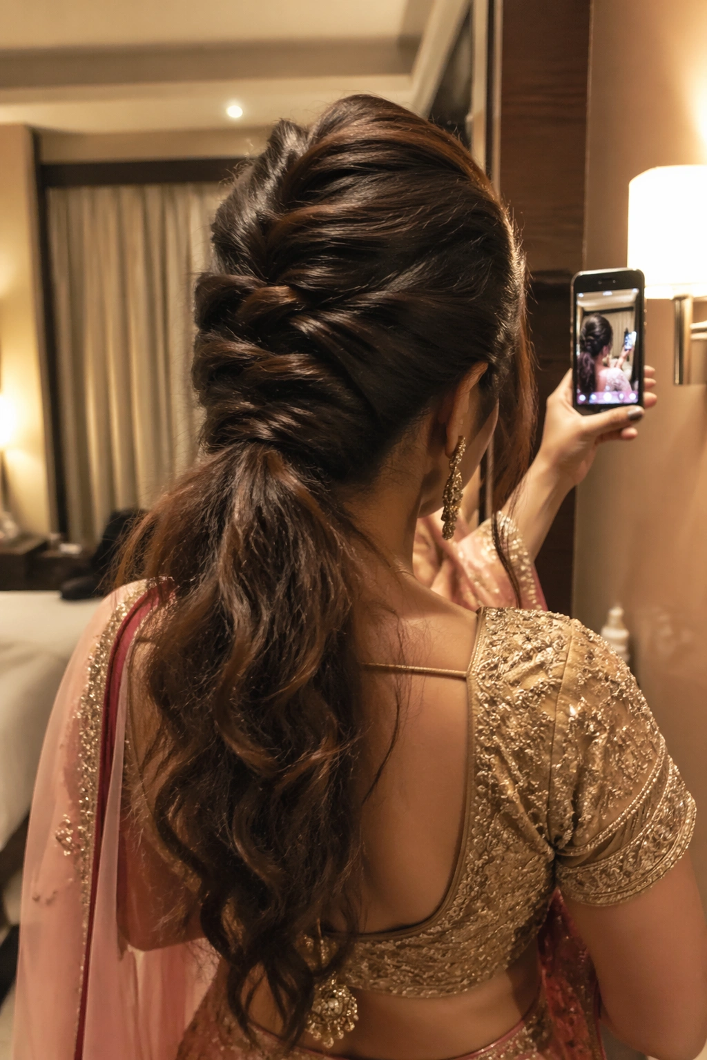 Over-the-shoulder mirror selfie of crisscross pinned ponytail.