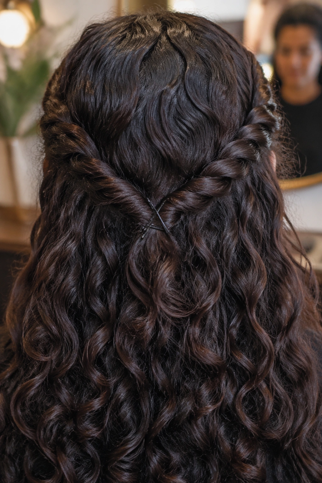 Close-up of a curly hairstyle showing a low V-shaped pin-back with curls cascading.
