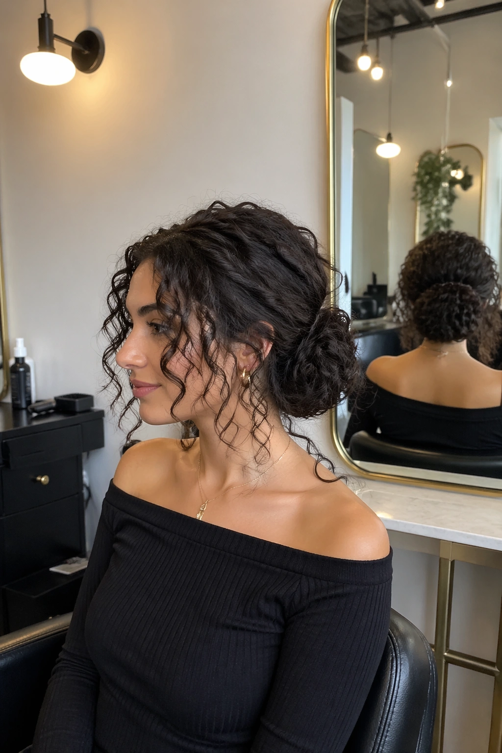 Wide shot of low curly chignon with face-framing pieces in a salon setting.