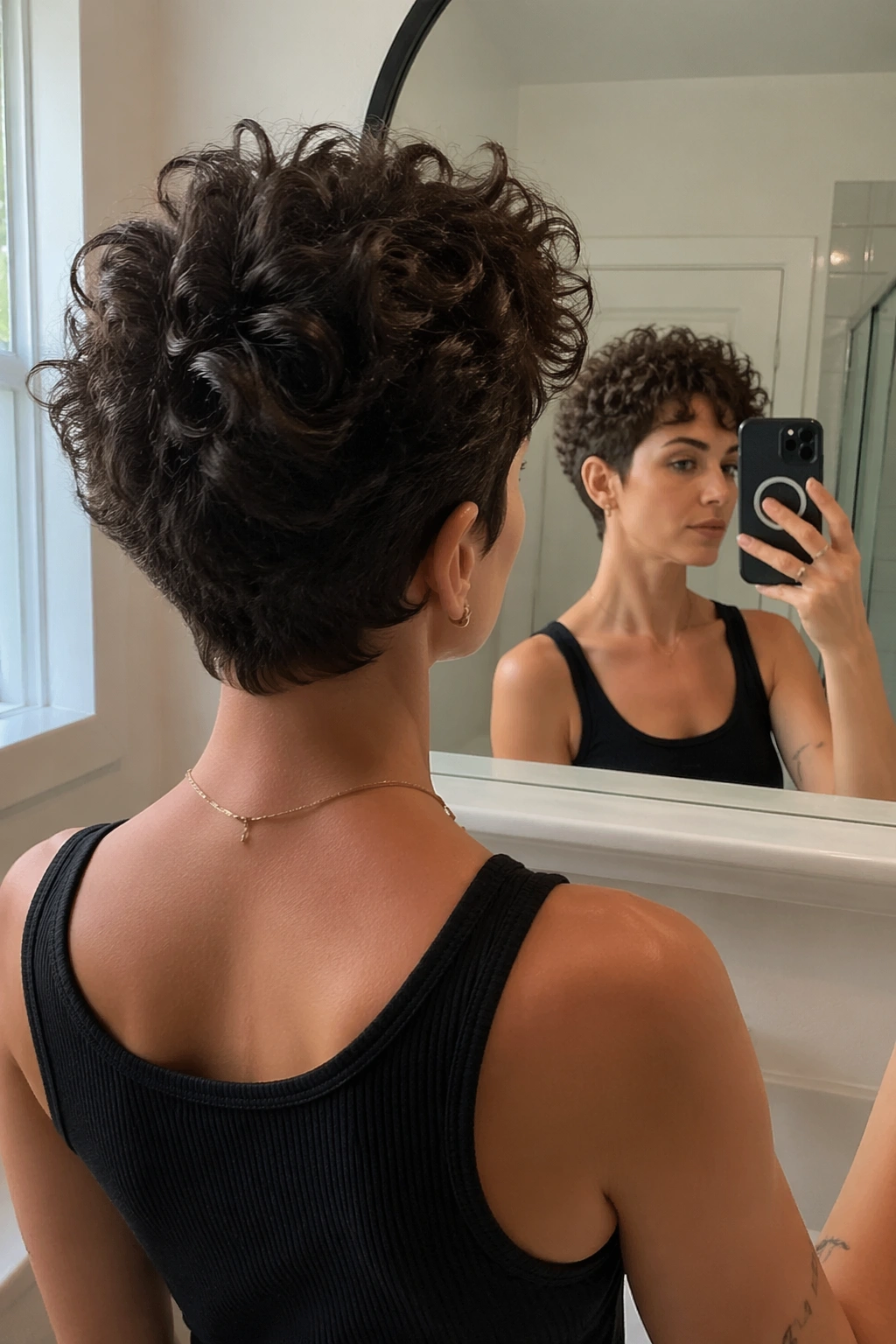 Curly pixie cut viewed in a bathroom mirror from a selfie pose.