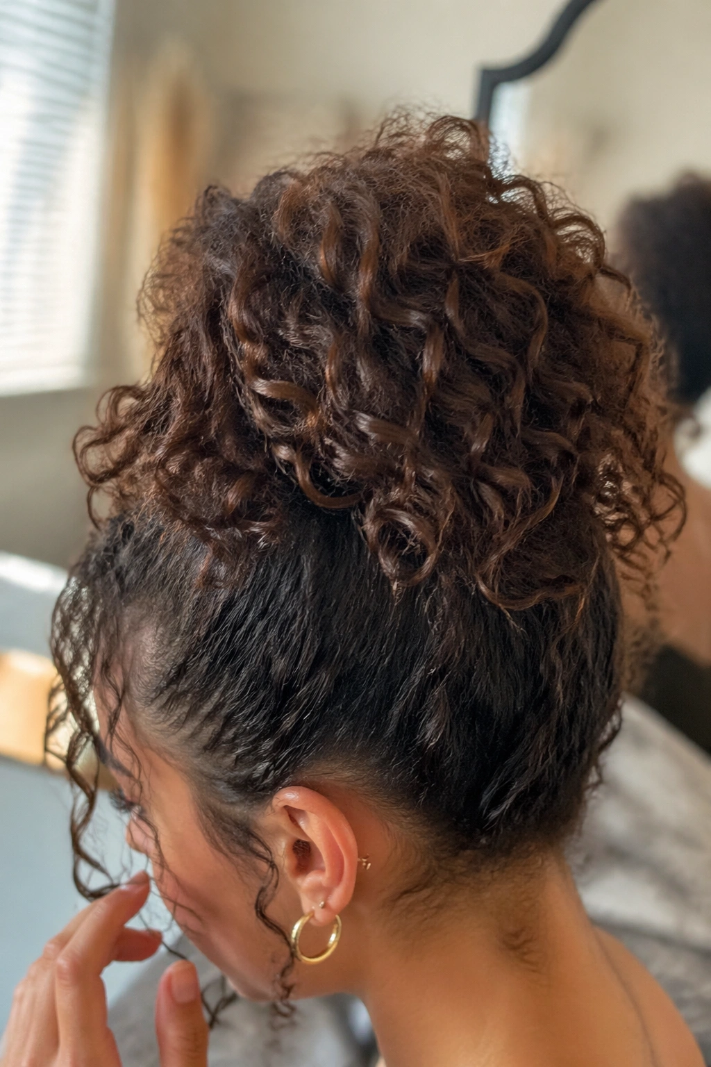 Close-up of a high curly ponytail with crown lift in soft morning light.