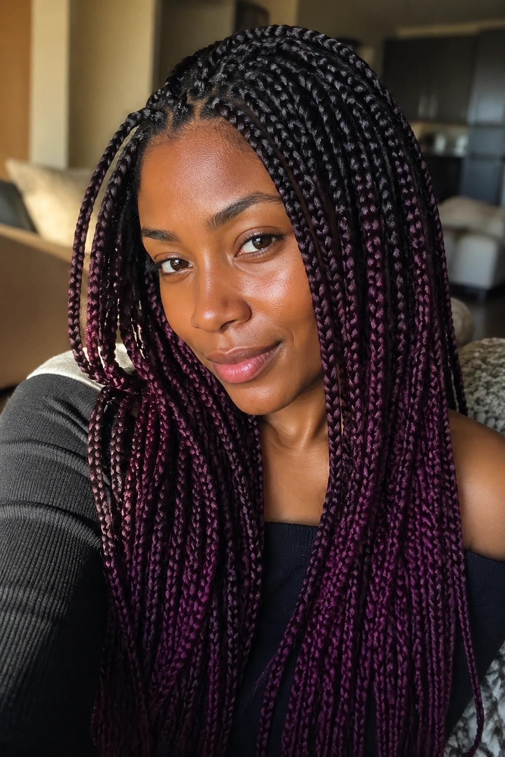 Close-up of deep plum ombré box braids on a real person with black roots fading to plum