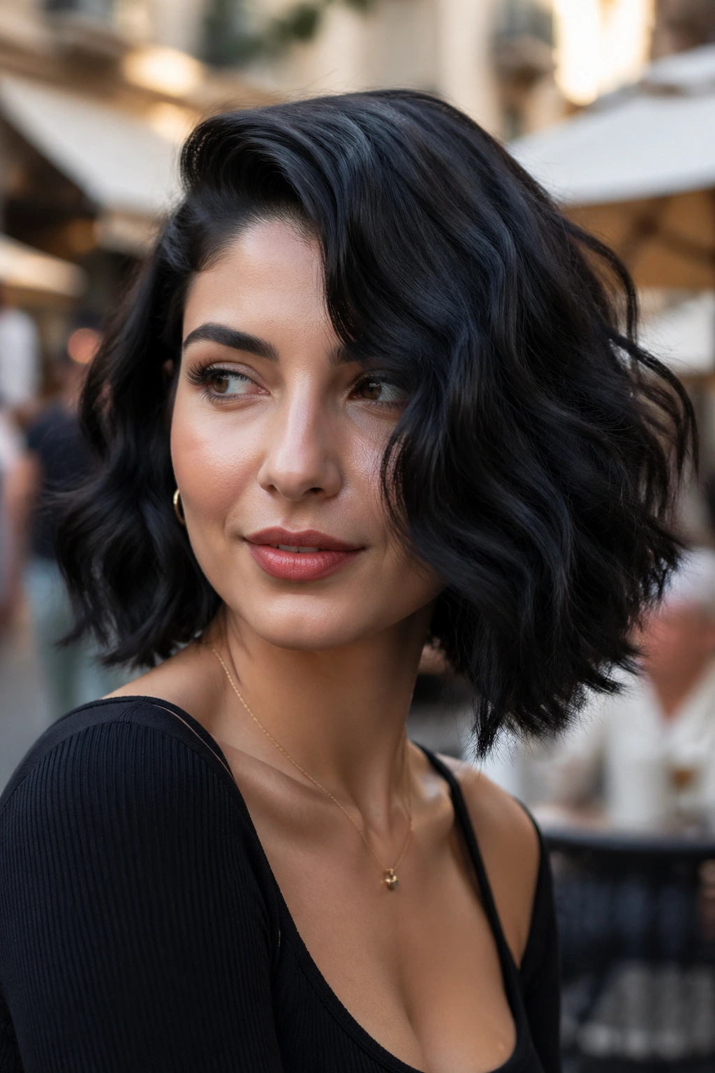 Close-up of a real woman with a deep side part and wavy bob in a city cafe