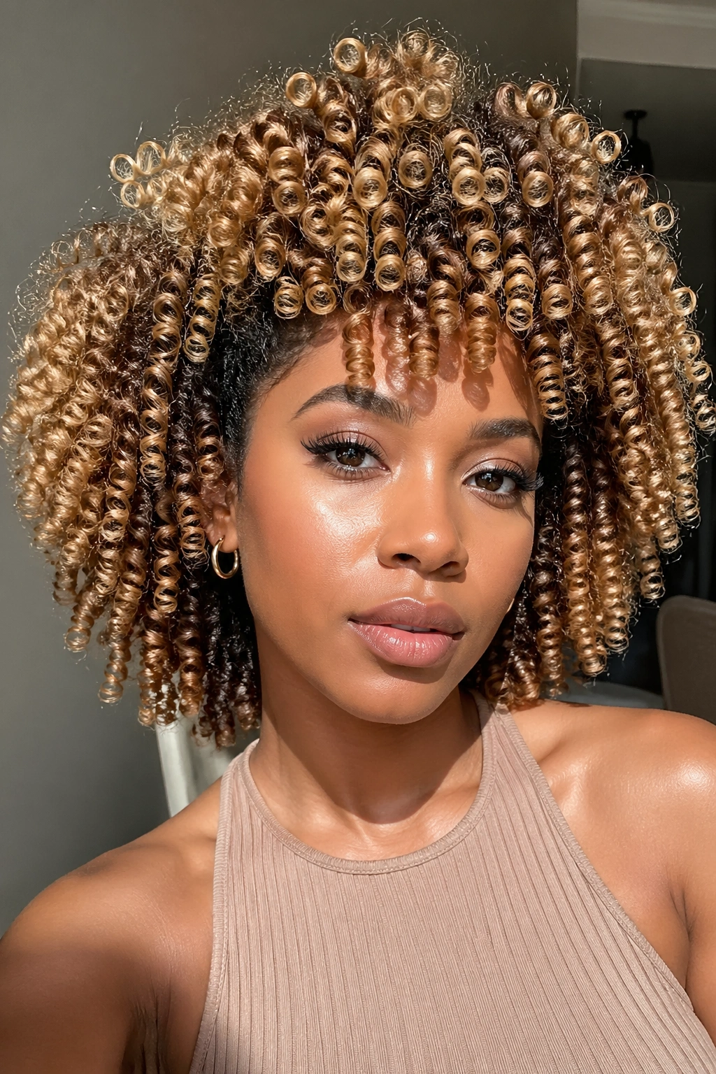 Close-up of defined honey blonde coils on a real person.