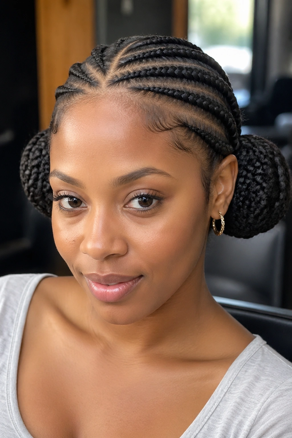 Close-up of a real woman with two milkmaid buns and cornrow connectors