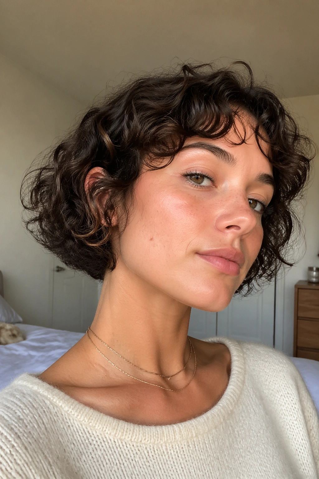 Close-up of a real person with an ear-length curly cut skimming the jaw