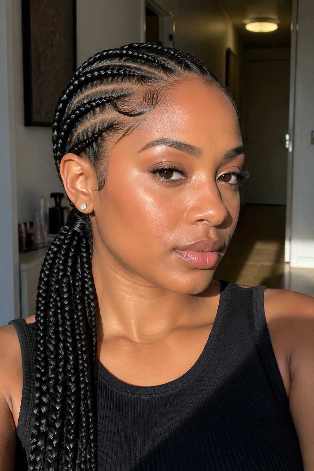 Woman with feed-in side braids forming a low ponytail