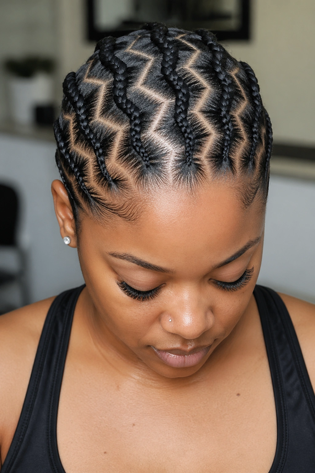 Close-up of a real woman with five symmetrical zigzag cornrows from hairline to nape.