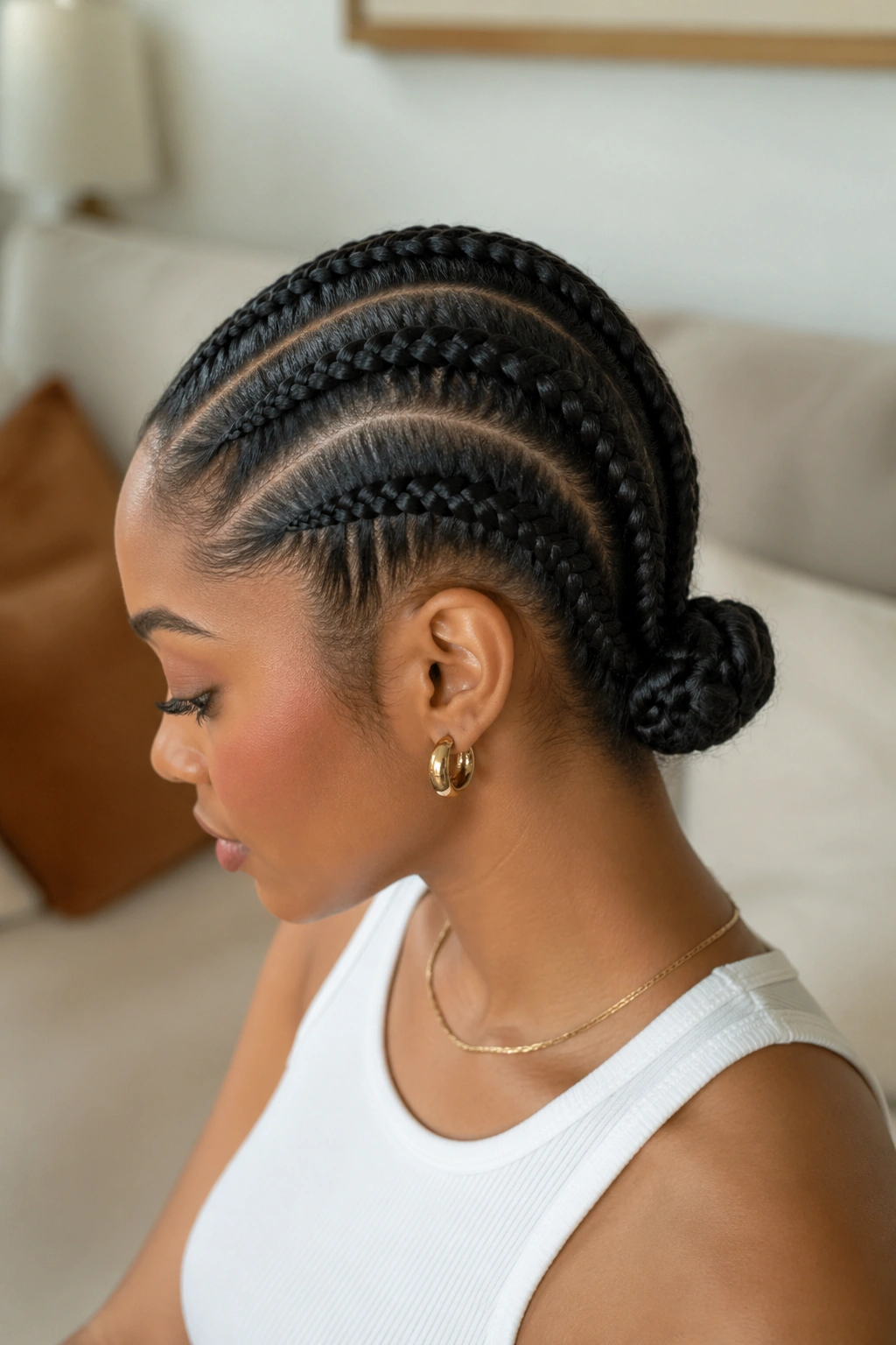 Real person with four cornrows pulled into a low bun.