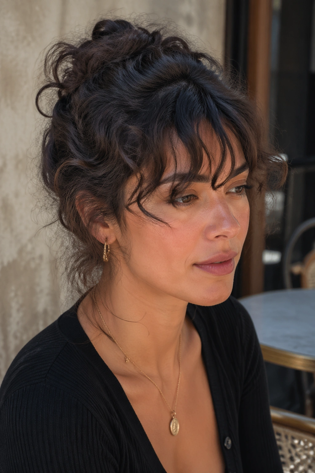 Close-up of a real woman with a messy French twist and piecey bangs