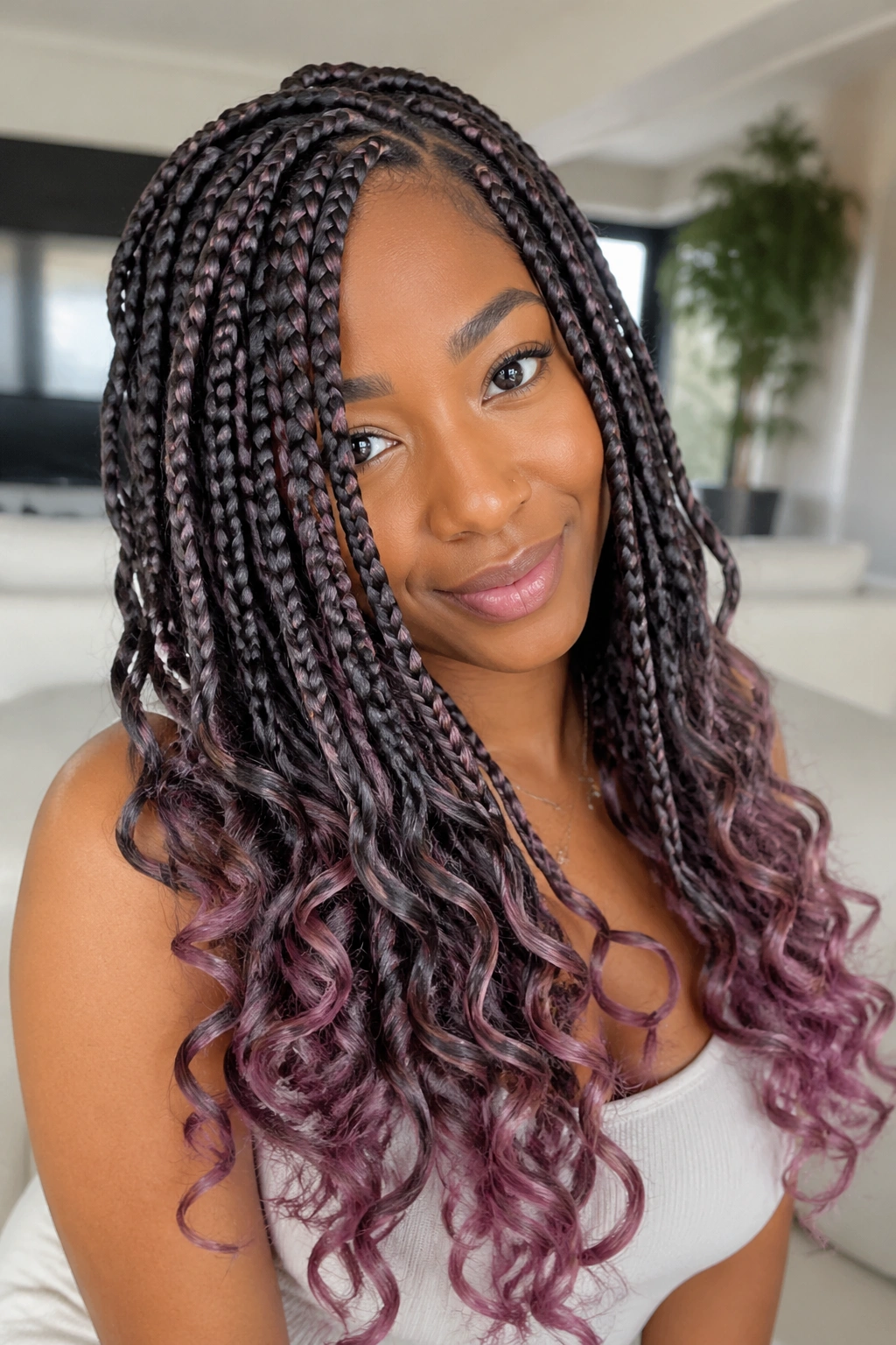 Close-up portrait of a real person with goddess box braids and mauve ends.
