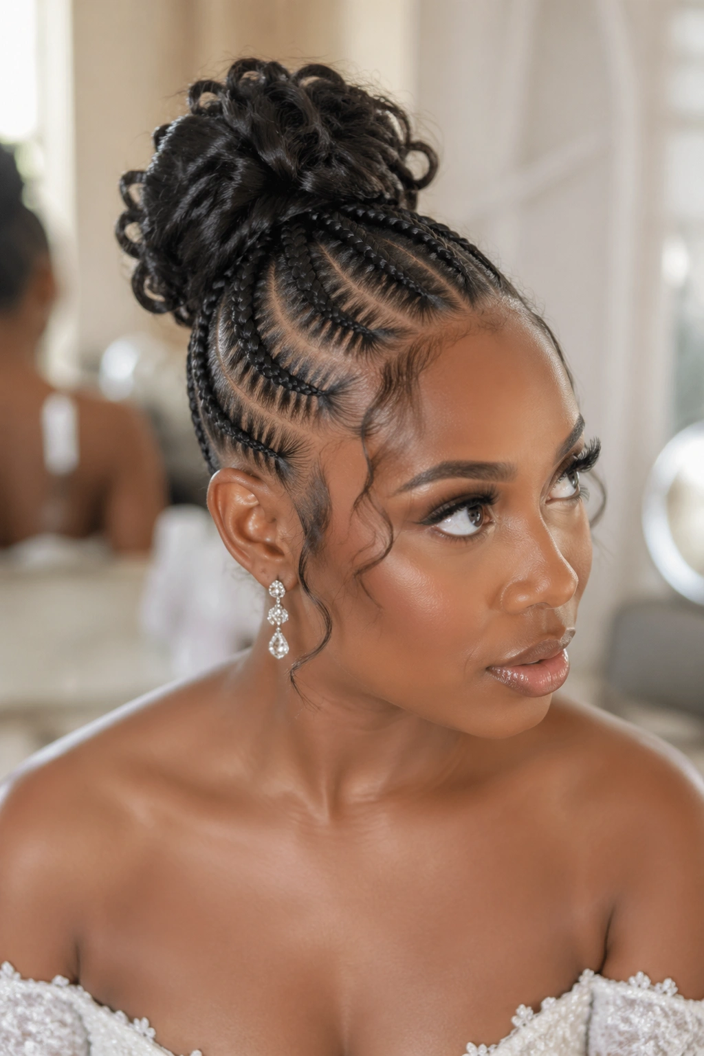 Close-up of a woman with a high bun formed from goddess cornrows, undone look and temple curls