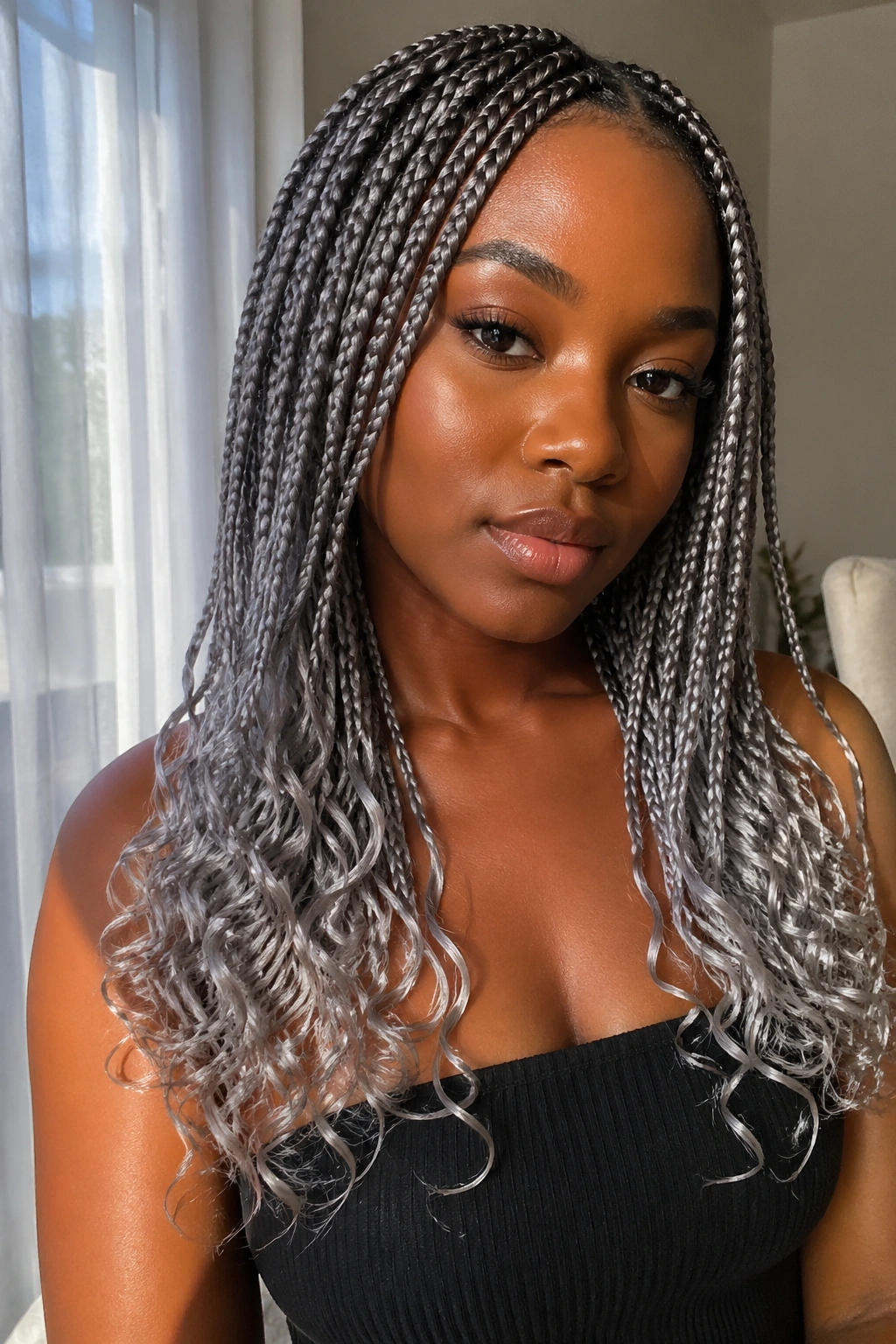 Close-up portrait of a woman with grey box braids ending in curls.