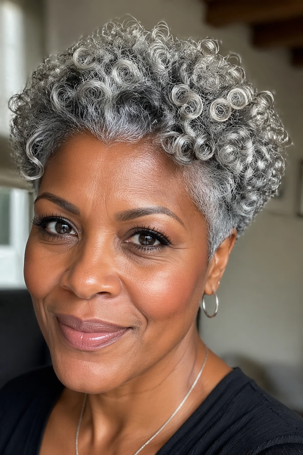 Close-up portrait of a woman with glossy grey short curls