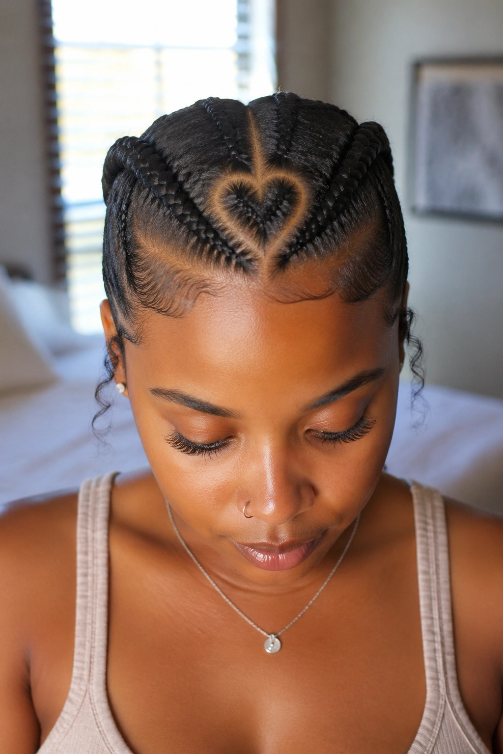 Close-up portrait of a real woman with a heart-shaped part and two cornrows sweeping back.