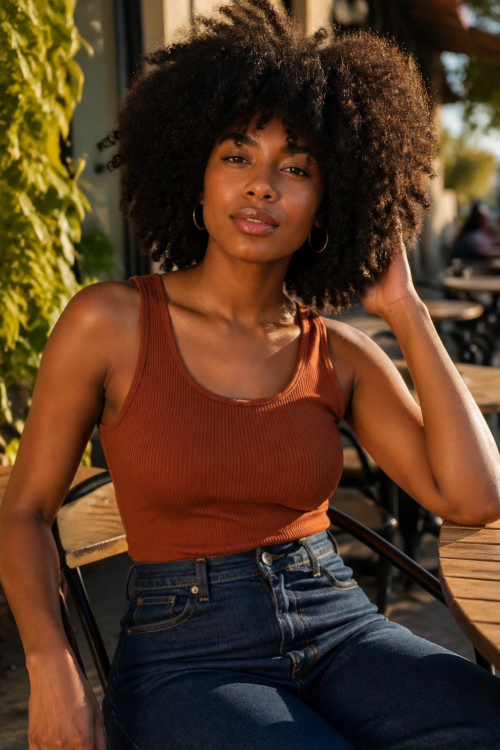 Mid-shot of a woman wearing high-waisted jeans and an earth-toned tank outdoors