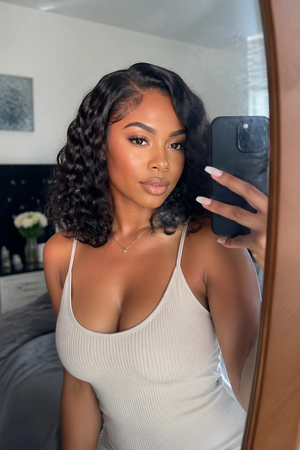 Mirror-selfie of layered curly lob at collarbone length.