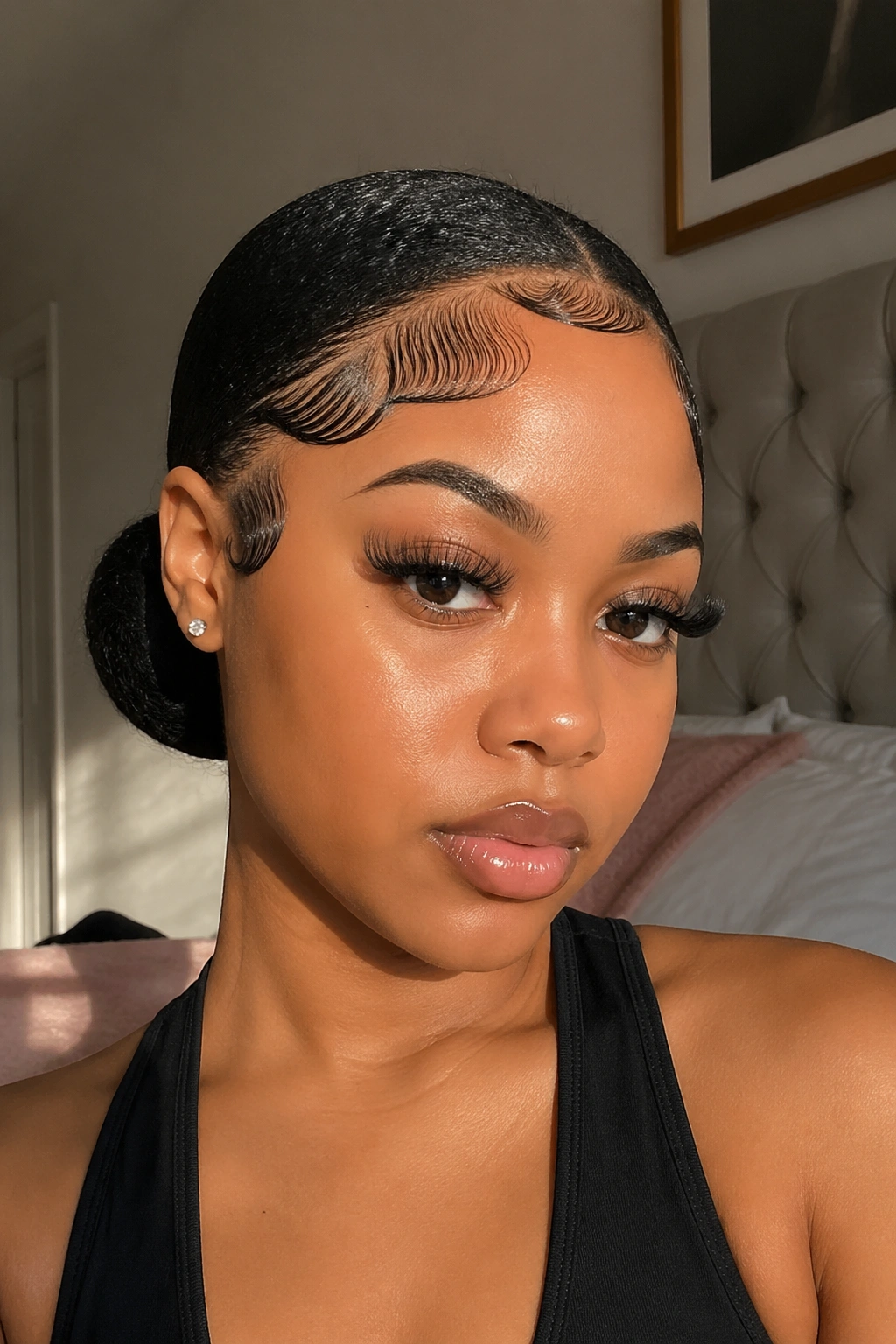 Close-up of a real woman with a low bun and dramatic edges at the hairline